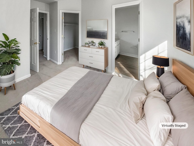 bedroom featuring a walk in closet, a closet, and ensuite bathroom