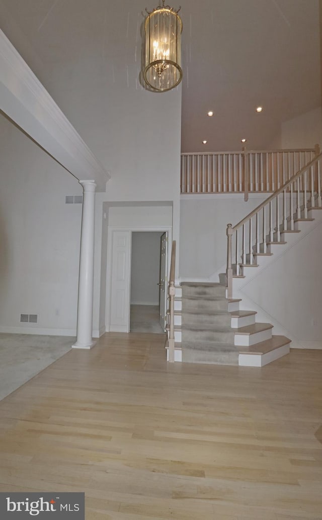 stairway with hardwood / wood-style floors and a high ceiling