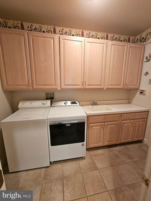 clothes washing area with cabinets, sink, and independent washer and dryer