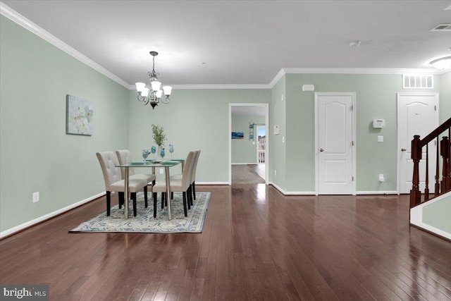 dining area with crown molding, dark hardwood / wood-style flooring, and an inviting chandelier