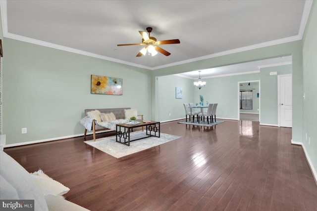 living room with ornamental molding, dark hardwood / wood-style floors, and ceiling fan with notable chandelier