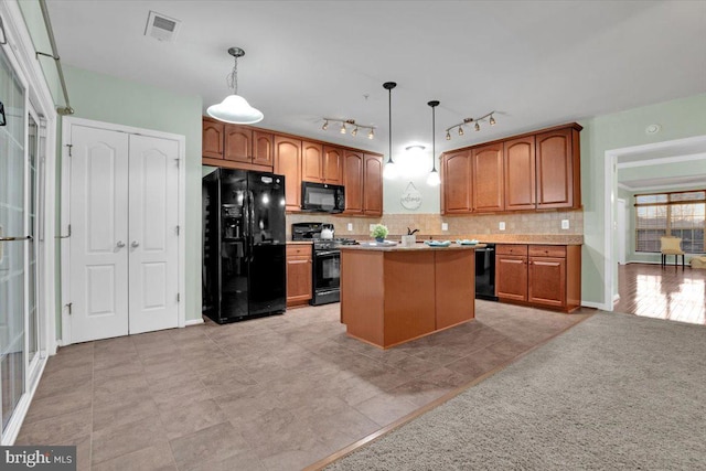 kitchen with pendant lighting, decorative backsplash, a kitchen island, and black appliances