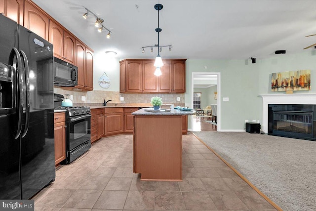 kitchen featuring pendant lighting, decorative backsplash, a center island, black appliances, and light carpet