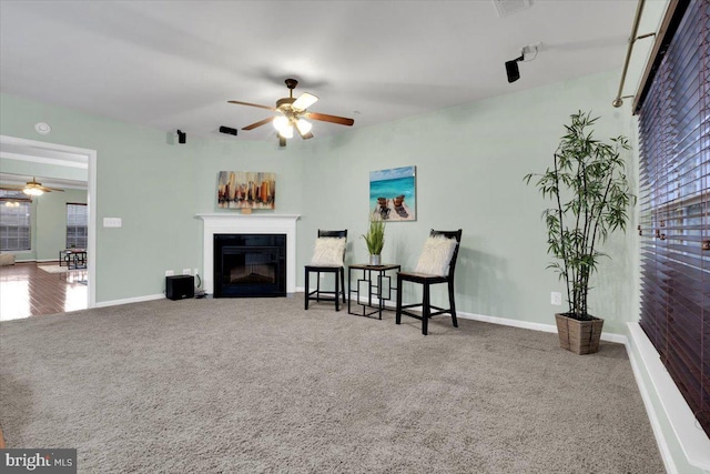 living area with ceiling fan and carpet flooring