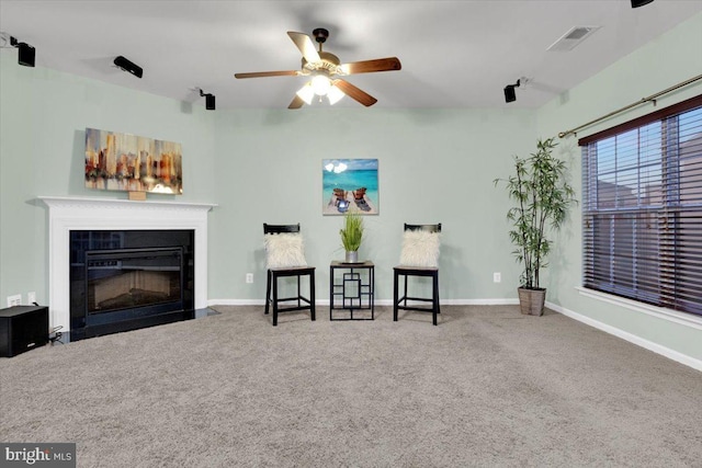 living area with ceiling fan and carpet floors