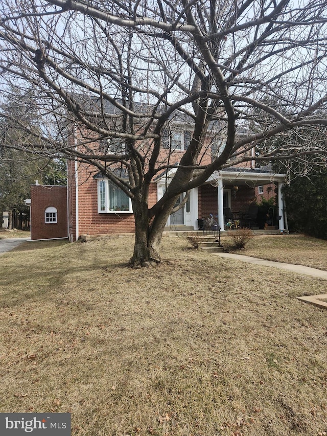 view of front of house featuring brick siding and a front lawn