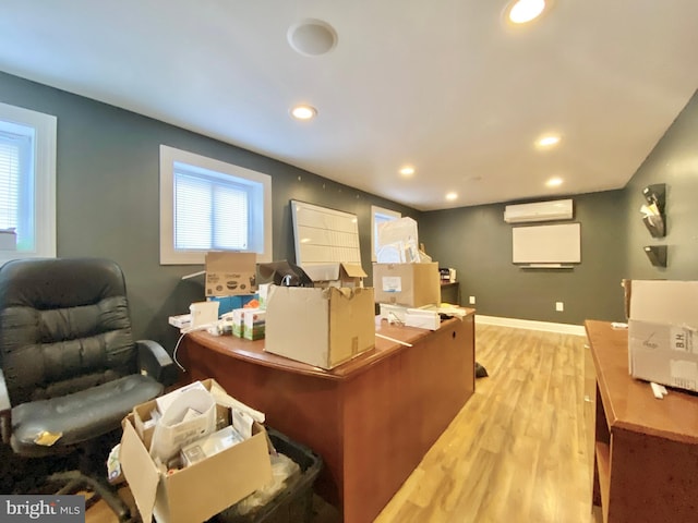 home office featuring a wall mounted air conditioner and light hardwood / wood-style flooring