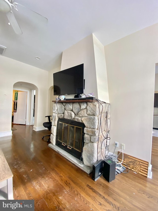 living room with hardwood / wood-style flooring and a stone fireplace