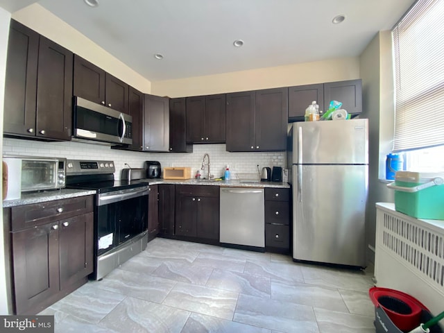 kitchen featuring dark brown cabinetry, sink, and appliances with stainless steel finishes