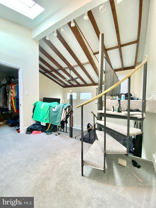 interior space featuring carpet and vaulted ceiling with skylight