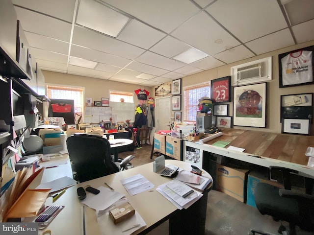 office space featuring a drop ceiling and an AC wall unit