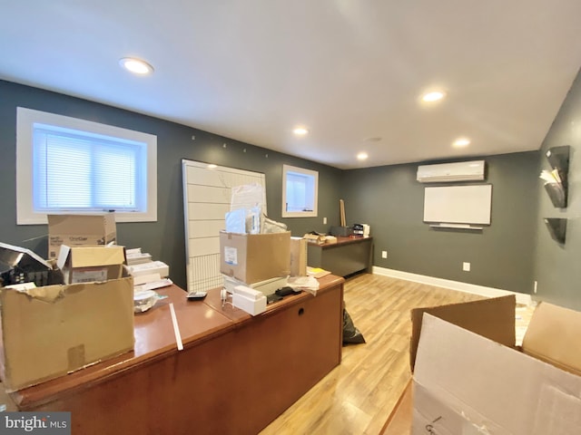 office area featuring a healthy amount of sunlight, a wall mounted AC, and light hardwood / wood-style floors