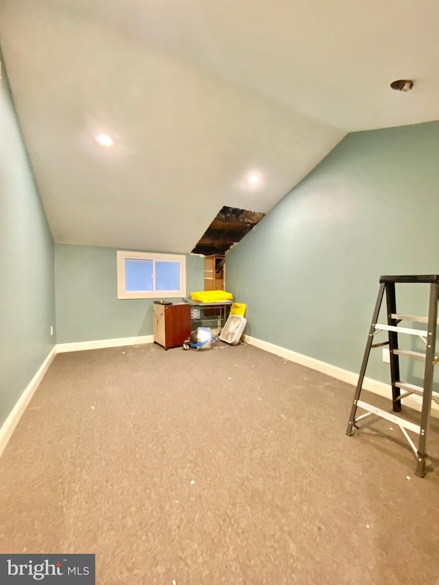 additional living space featuring carpet floors and vaulted ceiling