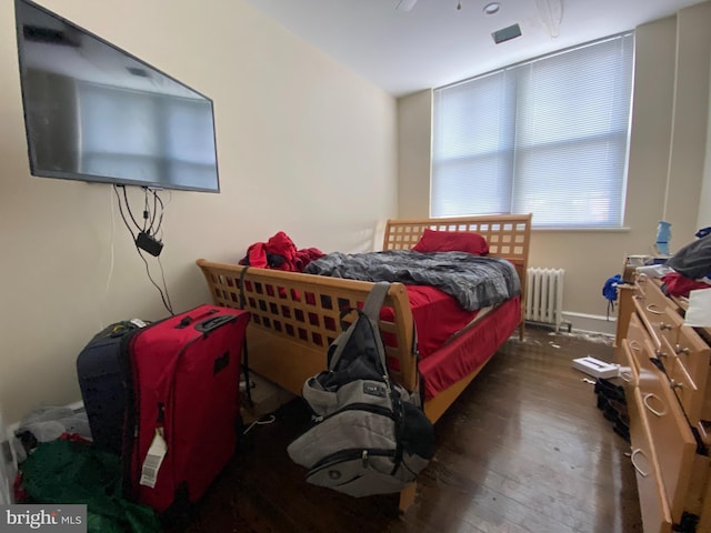 bedroom featuring dark hardwood / wood-style flooring and radiator