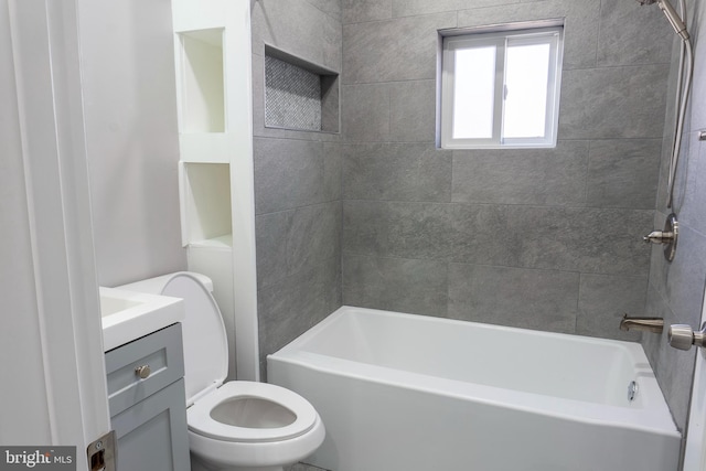 full bathroom featuring vanity, tiled shower / bath, and toilet