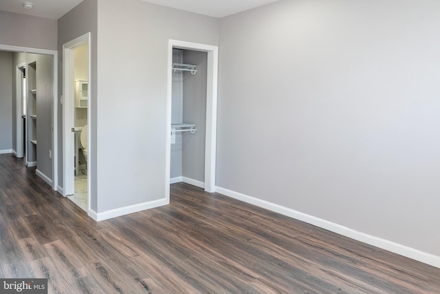 unfurnished bedroom with dark hardwood / wood-style floors and a closet