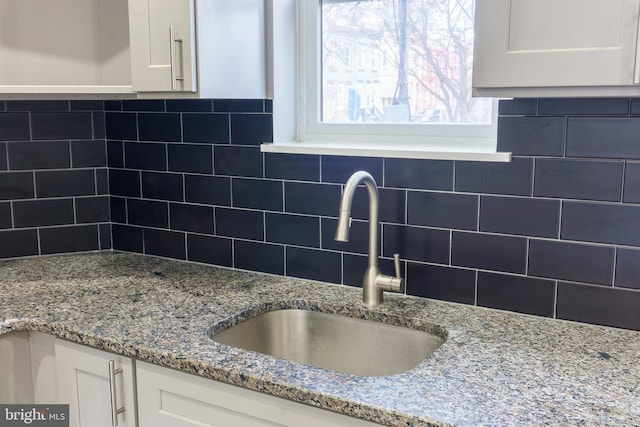 kitchen featuring white cabinetry, sink, and decorative backsplash