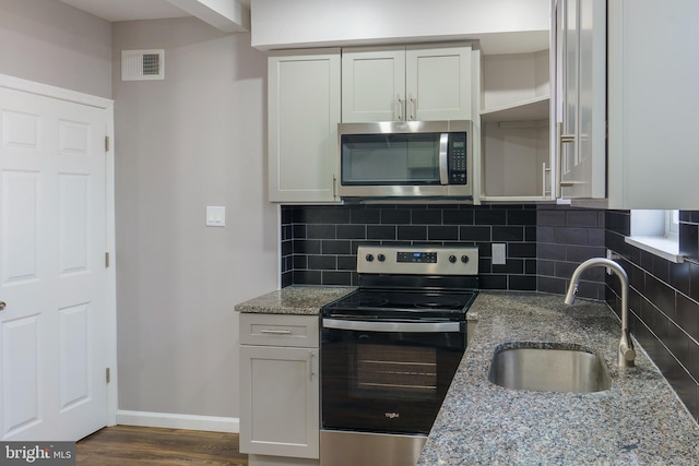 kitchen featuring sink, backsplash, white cabinets, light stone counters, and stainless steel appliances