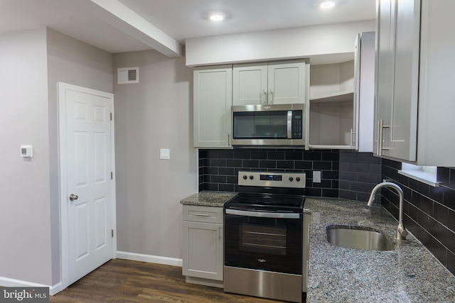 kitchen with sink, tasteful backsplash, dark hardwood / wood-style flooring, stone counters, and stainless steel appliances