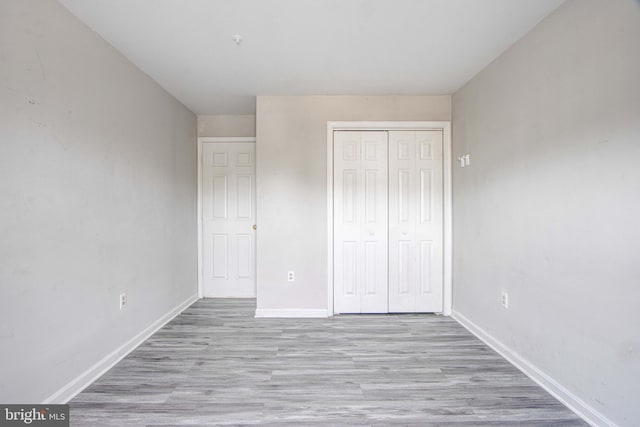 unfurnished bedroom with light hardwood / wood-style flooring and a closet