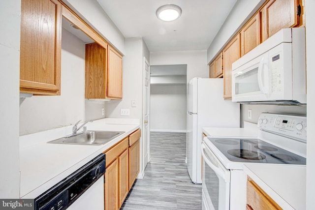 kitchen with white appliances, sink, and light wood-type flooring