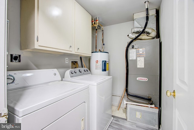 laundry area with heating unit, cabinets, washer and clothes dryer, light hardwood / wood-style floors, and water heater