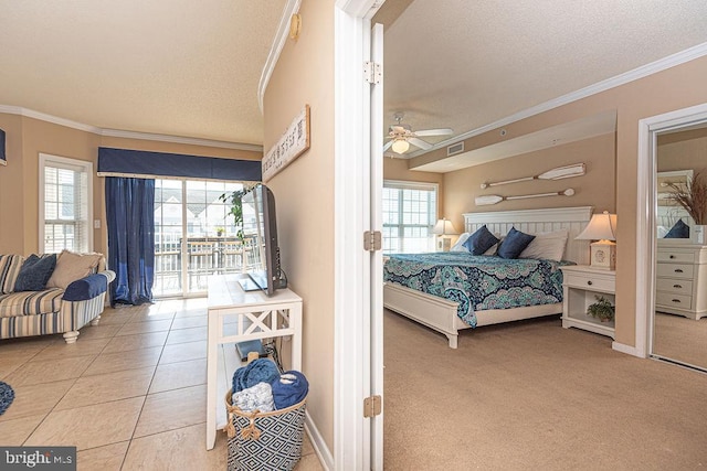 tiled bedroom featuring ornamental molding, access to exterior, and a textured ceiling