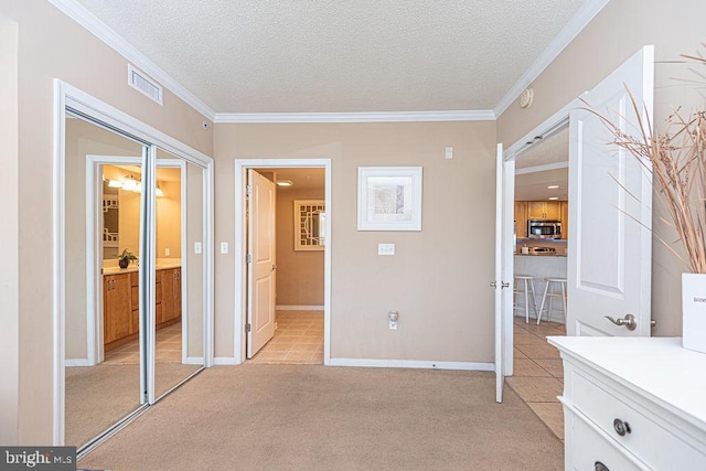 unfurnished bedroom featuring ornamental molding, light carpet, and a textured ceiling