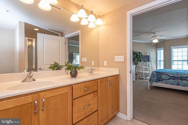 bathroom featuring vanity, ceiling fan, and a textured ceiling