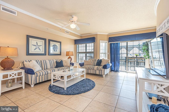 living room with ceiling fan, ornamental molding, a textured ceiling, and light tile patterned floors