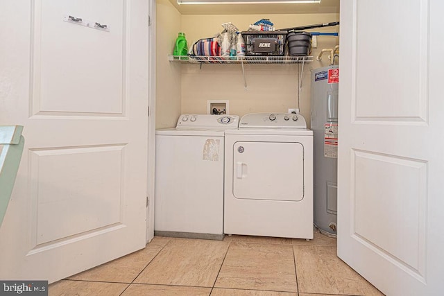 laundry room with electric water heater, light tile patterned floors, and washer and clothes dryer