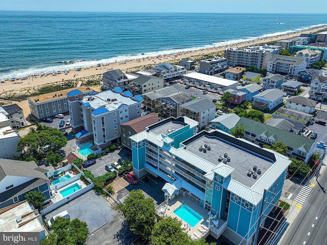 drone / aerial view with a water view and a beach view