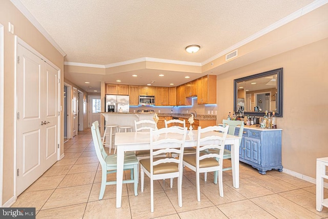 tiled dining area with crown molding and a textured ceiling