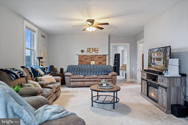 carpeted living room featuring ceiling fan and a brick fireplace