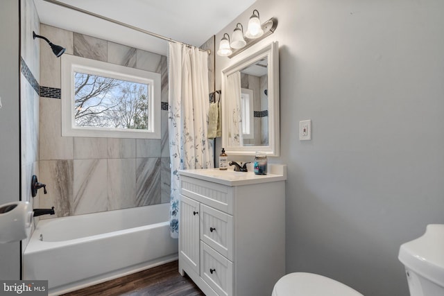 full bathroom with hardwood / wood-style flooring, vanity, shower / tub combo with curtain, and toilet