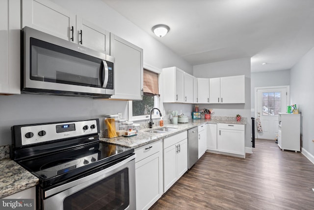 kitchen featuring sink, dark wood-type flooring, appliances with stainless steel finishes, light stone counters, and white cabinets