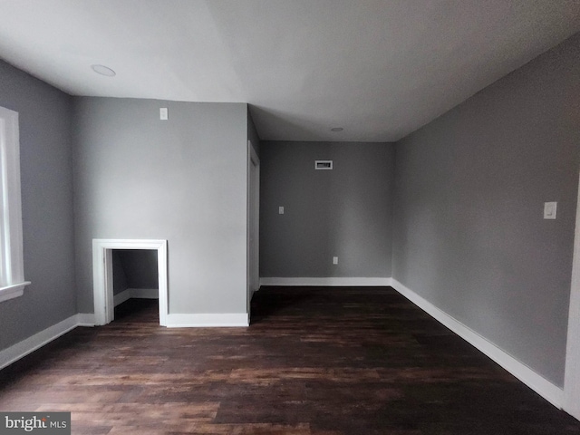 unfurnished room with dark hardwood / wood-style flooring