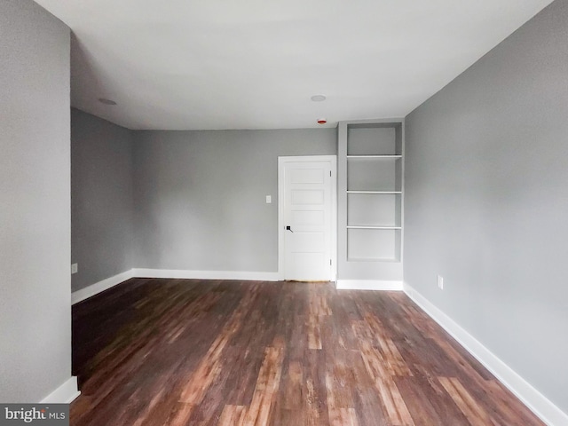 spare room with dark hardwood / wood-style flooring