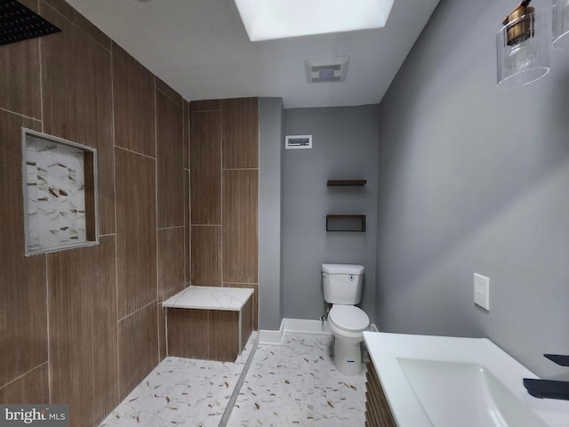 bathroom featuring a shower, vanity, and toilet