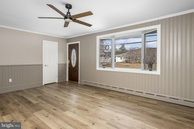 entrance foyer featuring crown molding, a baseboard radiator, ceiling fan, and light hardwood / wood-style flooring