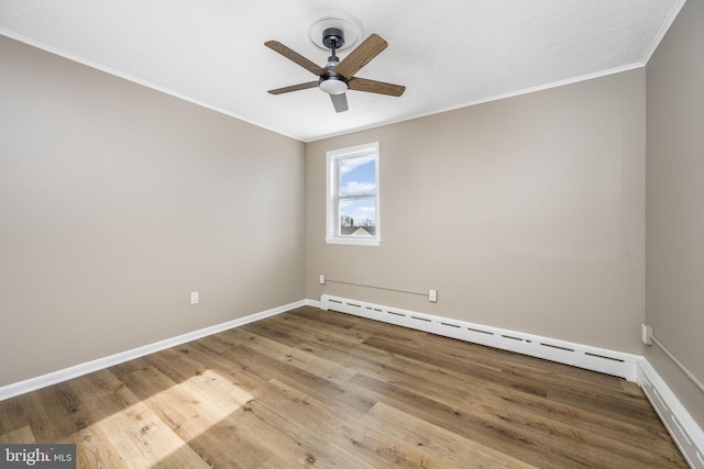 empty room with baseboard heating, ceiling fan, crown molding, and hardwood / wood-style flooring