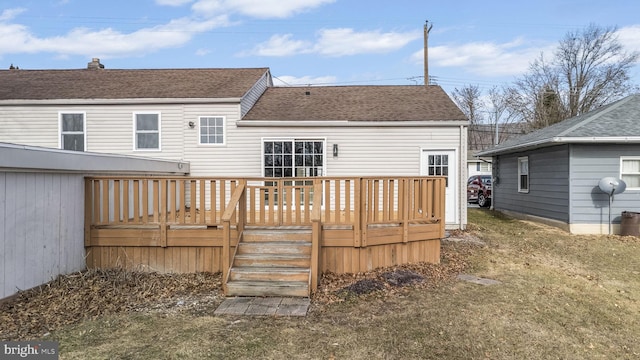 rear view of property featuring a lawn and a deck