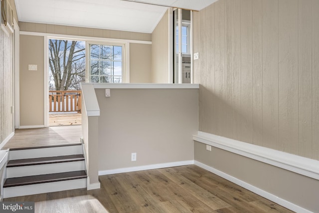 stairs featuring hardwood / wood-style floors and wood walls