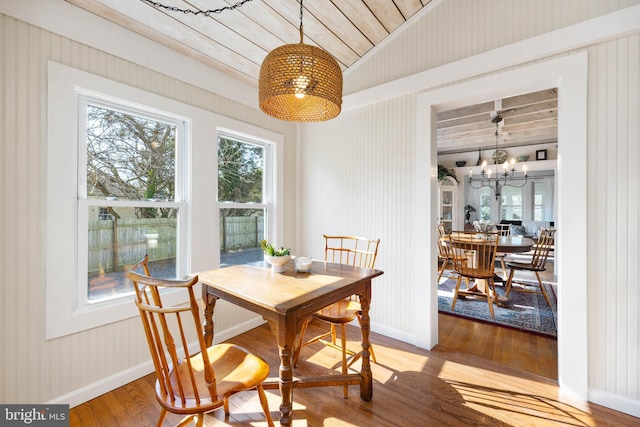 dining room featuring hardwood / wood-style flooring, wood ceiling, and a notable chandelier