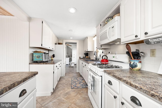 kitchen featuring tasteful backsplash, white cabinetry, sink, ceiling fan, and white appliances