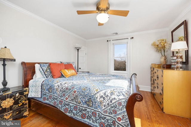 bedroom with wood-type flooring, ornamental molding, and ceiling fan