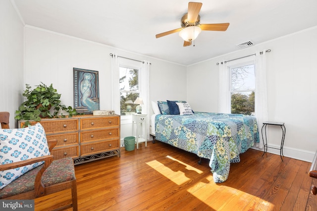 bedroom with ceiling fan, ornamental molding, and dark hardwood / wood-style floors