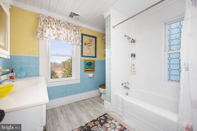 full bathroom featuring toilet, tile walls, ornamental molding, vanity, and shower / bathtub combination with curtain