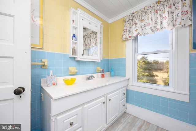 bathroom featuring hardwood / wood-style flooring, ornamental molding, tile walls, and vanity