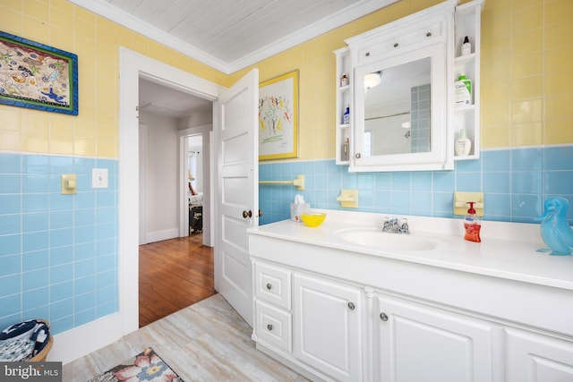 bathroom featuring crown molding, vanity, hardwood / wood-style floors, and tile walls